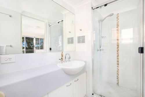 卡伦德拉贝尔韦代雷公寓的白色的浴室设有水槽和淋浴。