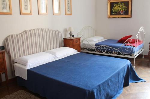 比耶拉德尔皮亚佐住宿加早餐旅馆的一间卧室配有一张床和一把带蓝色毯子的椅子