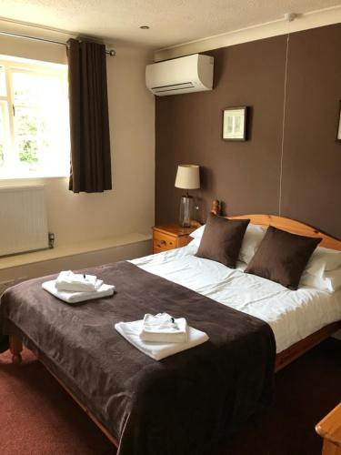兰波特The Old Pound Inn的一间卧室配有一张大床和两条毛巾
