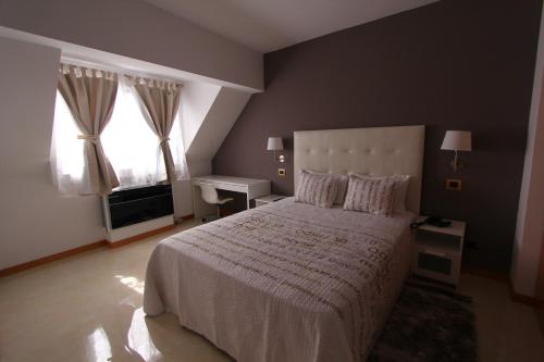 明德卢Morenos Boutique Hotel的一间卧室设有一张大床和一个窗户。