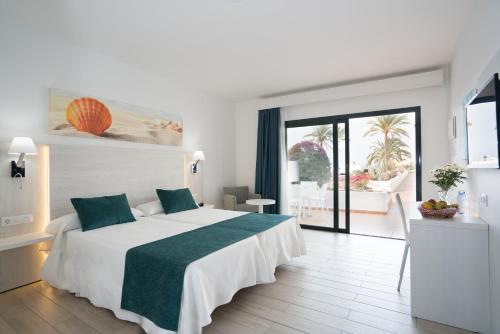 卡门港THB花卉酒店的卧室配有一张带绿毯的大型白色床