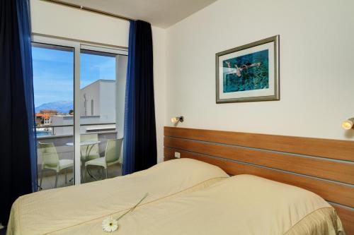 波斯蒂拉玛丽亚公寓的一间卧室设有一张床和一个大窗户