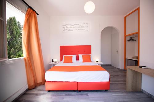 帕罗奇亚Acqua Vatos Paros Hotel的一间卧室配有一张带橙色和白色床单的大床