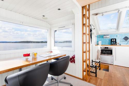 奥斯陆Beach house in Oslo的船上的厨房和用餐室,配有桌椅