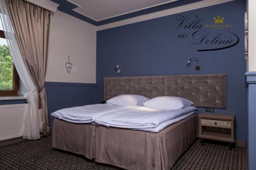 塔尔努夫Apartamenty Willa w Dolinie的一间卧室配有一张蓝色墙壁的床