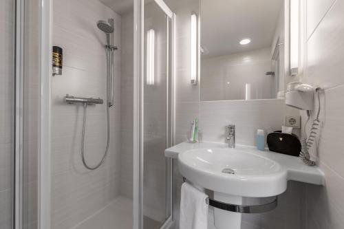 蒙塔鲍尔海利根罗特塞威酒店的带淋浴和盥洗盆的白色浴室