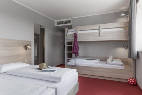 福伊赫特福伊特奥斯特苏维酒店的带两张双层床的客房中的两张床