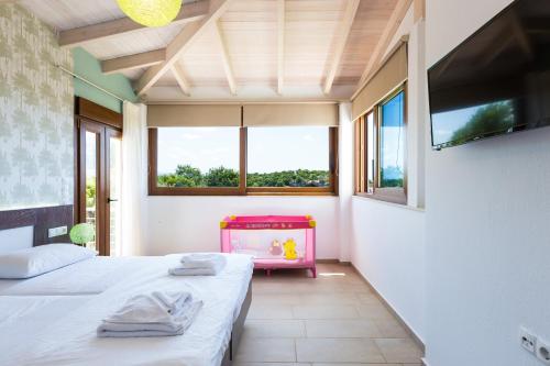 AchladesKampos Villas, pure elegance, By ThinkVilla的带2扇窗户的客房内的2张床