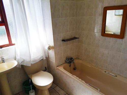 马盖特Dumela Margate Flat No 31的浴室配有卫生间、浴缸和水槽。