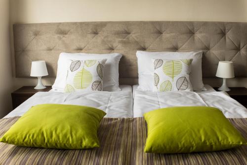 什切青City Rooms Szczecin的一张大床,上面有两个绿色枕头