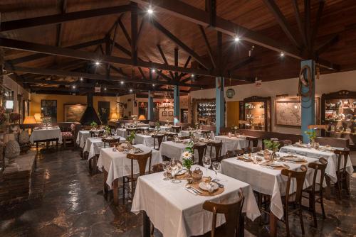邦雅尔丁-达塞拉里约都拉斯特罗生态度假酒店的一间设有白色桌椅的用餐室