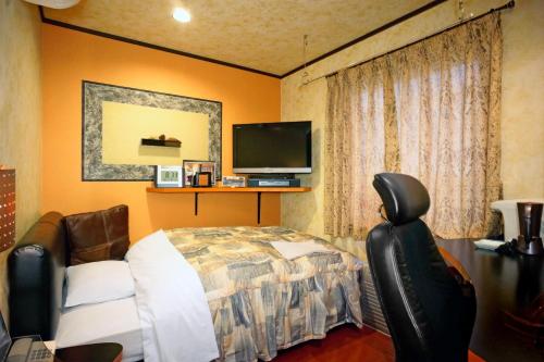 萨摩川内市卫星酒店的一间卧室配有一张床和一台平面电视