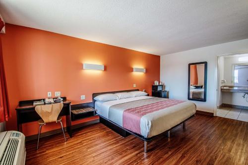 Falling Waters马丁斯堡6号汽车旅馆的一间卧室配有一张床、一张桌子和一张四柱床。