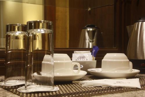 马尼拉Herald Suites Polaris的桌子上放有盘子和杯子,杯子