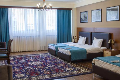 久姆里Hotel Plaza Viktoria的酒店客房带两张床和地毯