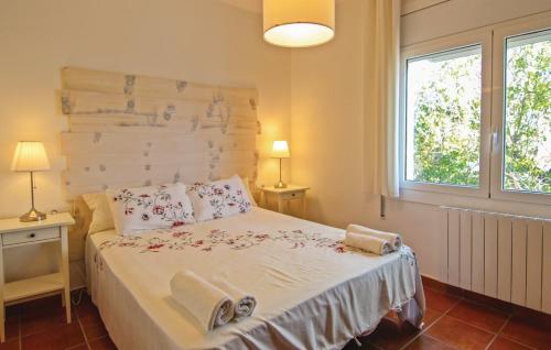 皮内达德马尔Can Pinemar的一间卧室配有一张带两盏灯的床和一扇窗户。