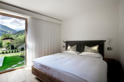 坎波图雷斯卡伦那别墅公寓式酒店的一间卧室设有一张床和一个大窗户