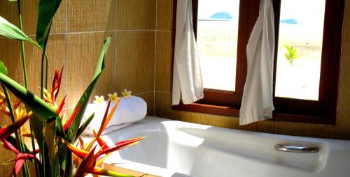 塔林甘海滩安卡天堂度假酒店的一间带白色浴缸和2扇窗户的浴室
