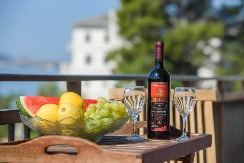 卡什泰拉Luxury Rooms Ivana的一瓶葡萄酒和一碗水果及酒杯