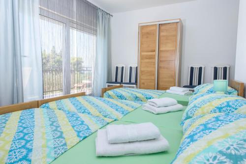 卡什泰拉Luxury Rooms Ivana的一间卧室配有两张带毛巾的床