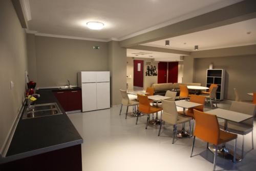 塞萨洛尼基斯戴海波旅舍的厨房以及带桌椅的用餐室。