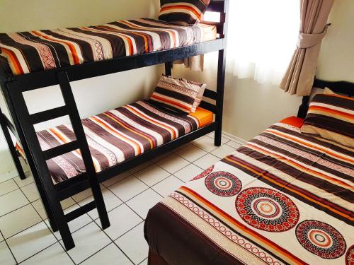 马盖特Dumela Margate Flat 21的一间客房内配有两张双层床的房间