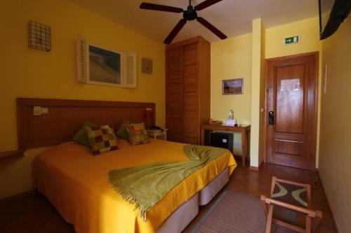 明德卢基拉精品酒店的一间卧室配有一张床和吊扇
