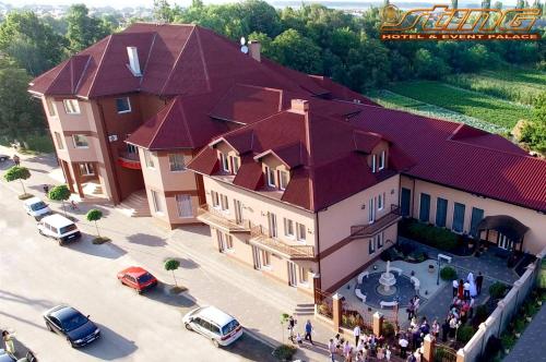 Velikaya DobronʼSting Hotel & Event Palace的一座大型建筑,有红色屋顶,外面有人