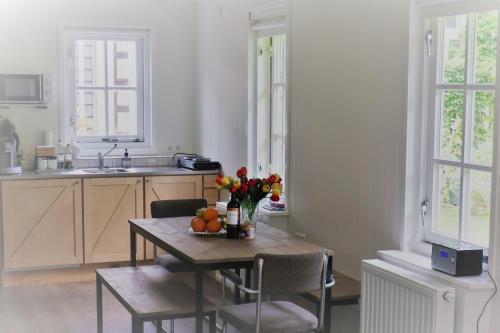 阿姆斯特丹吉娜花园别墅公寓的厨房配有带鲜花和水果的桌子
