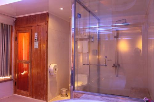 芦竹比佛利商务汽车旅馆的带淋浴的浴室和玻璃门