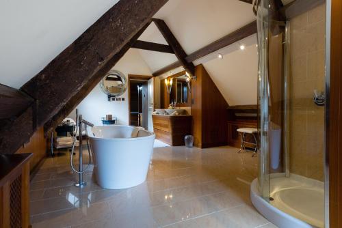 马姆斯伯里惠特利庄园酒店的大型浴室设有浴缸和淋浴。
