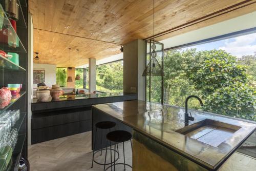 塔巴南Chameleon Villa Bali的一个带水槽的开放式厨房和大窗户