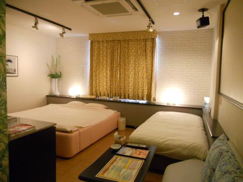 明石市马雷情趣酒店（仅限成人入住）的酒店客房设有两张床和一张桌子。