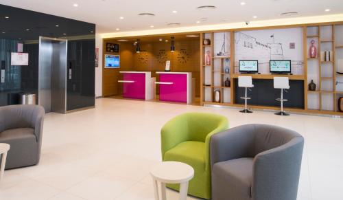 麦纳麦ibis Styles Manama Diplomatic Area的大楼内带桌椅的大堂