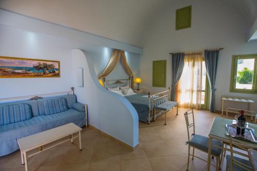 卡马利ansa豪华套房酒店的一间卧室配有蓝色的沙发和一张床