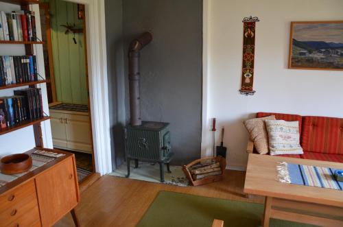 MindresundeTunold Gård - Gamle huset的客厅配有炉灶和沙发。