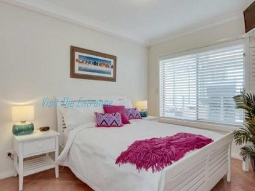 安特兰斯海洋松4号度假屋的白色的卧室设有一张大床和一个窗户