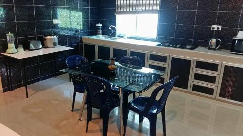 波德申Port Dickson Holiday Home Villa的厨房配有桌椅和柜台。