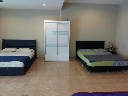 波德申Port Dickson Holiday Home Villa的一间卧室配有两张床和白色橱柜
