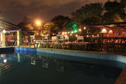 耶尔瓦布埃纳Pura vida Mae Hostel的游泳池在晚上配有桌椅