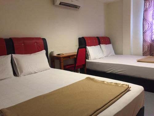 士姑来奥菲尔酒店的酒店客房设有两张床和一张桌子。