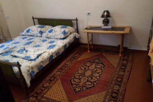 叶海格纳佐尔Spandaryan House的一间卧室配有一张床、一张桌子和一张地毯。