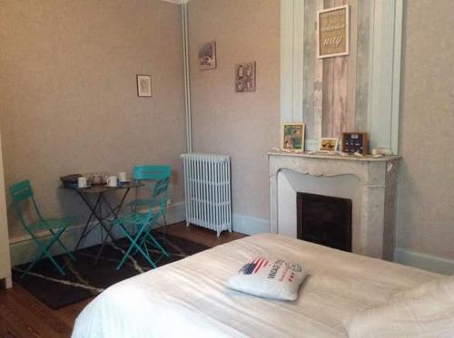Saint-Pierre-Églisela Tourelle en Normandie的一间卧室配有一张床、一个壁炉和一张桌子