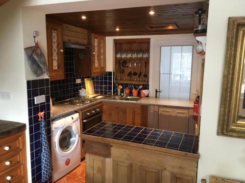 伦敦德里Erin Cottage的厨房配有水槽和洗衣机