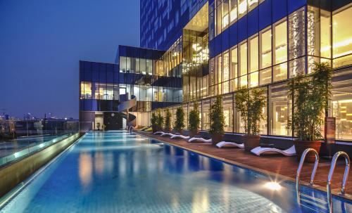 雅加达Vertu Harmoni Jakarta的一座游泳池,在晚上在建筑物前