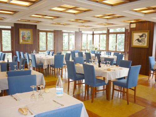 坎丹奇奥坎丹丘酒店的用餐室配有白色的桌子和蓝色的椅子