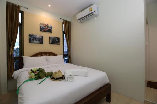 Nang Rongโรงแรมนางรอง的一张带帽子和毛巾的白色床