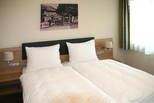 Sankt Peter am Wimberg豪厄维特宾馆 的床上有2个白色枕头