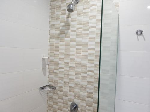 纳闽巴霍纳闽巴霍马塔哈里酒店 的带淋浴的浴室和玻璃门