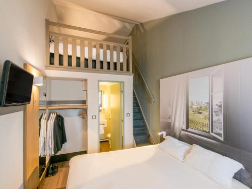 梅里尼亚克B&B HOTEL Bordeaux Mérignac Hôtel de Ville的一间小卧室,配有一张床和一个楼梯